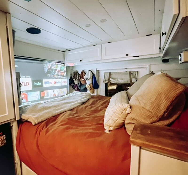 Our bedroom with our queen-size mattress. We have a pull-down projector for our TV. We love our cozy space.