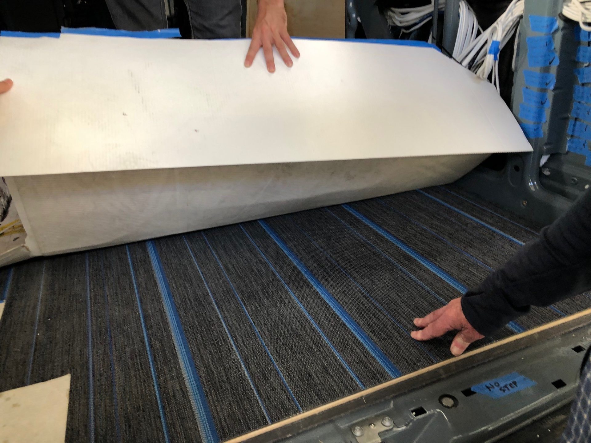 Installing the flooring. This polymer flooring looks like carpet, but is easy to clean.