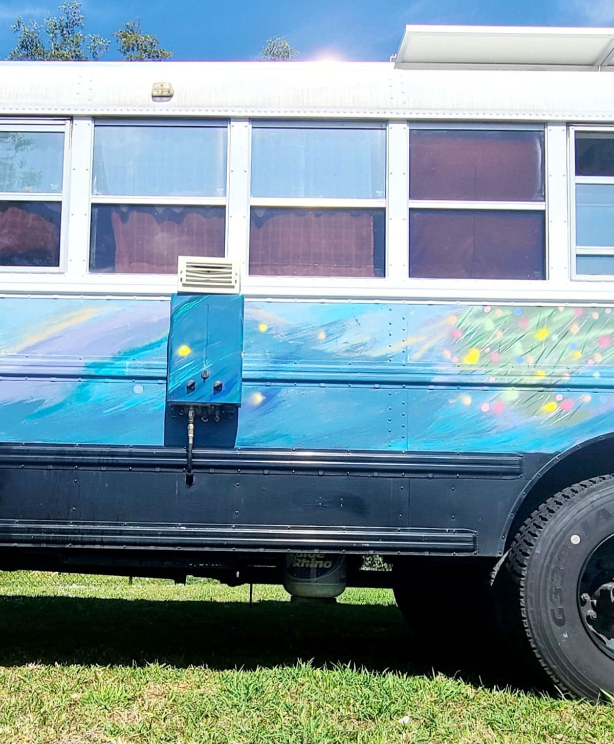 The water heater is mounted to the side of the bus
